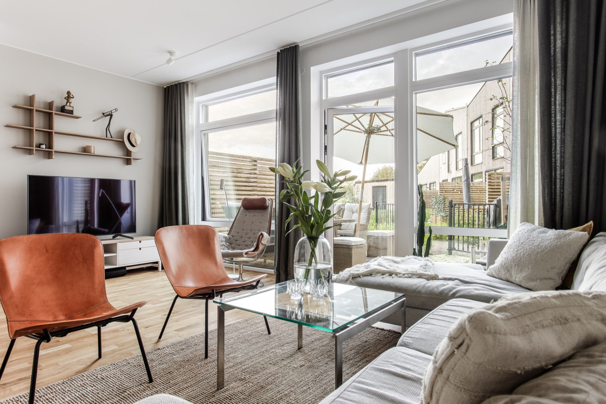 Vardagsrum med generösa fönsterpartier och direkt utgång till ena uteplatsen Ridvägen 29E