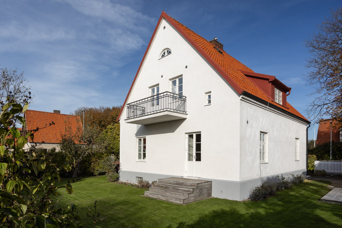 Fastigheten reser sig ståtligt när solens strålar skiner mot den ljusa kalkputsen Värmlandsgatan 10